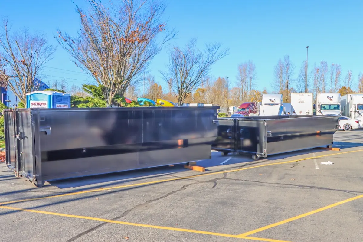 Professional dumpster rental service with roll-off container on residential driveway in Bessemer